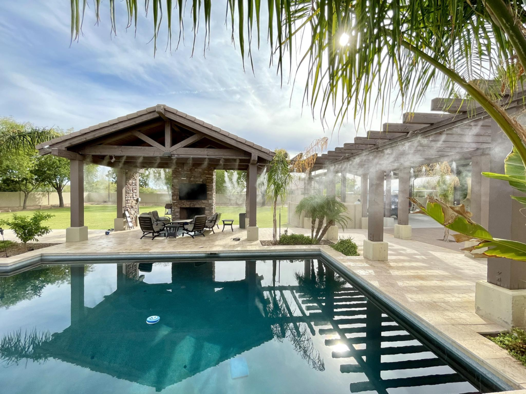 Element Mist backyard patio misting system install, picturing a pool, palm trees, and a pergola