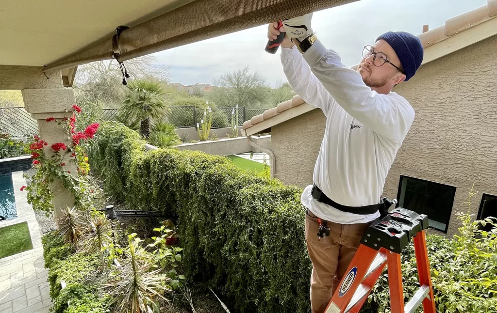 Another element mist team member on a ladder installing a misting system in an arizona backyard