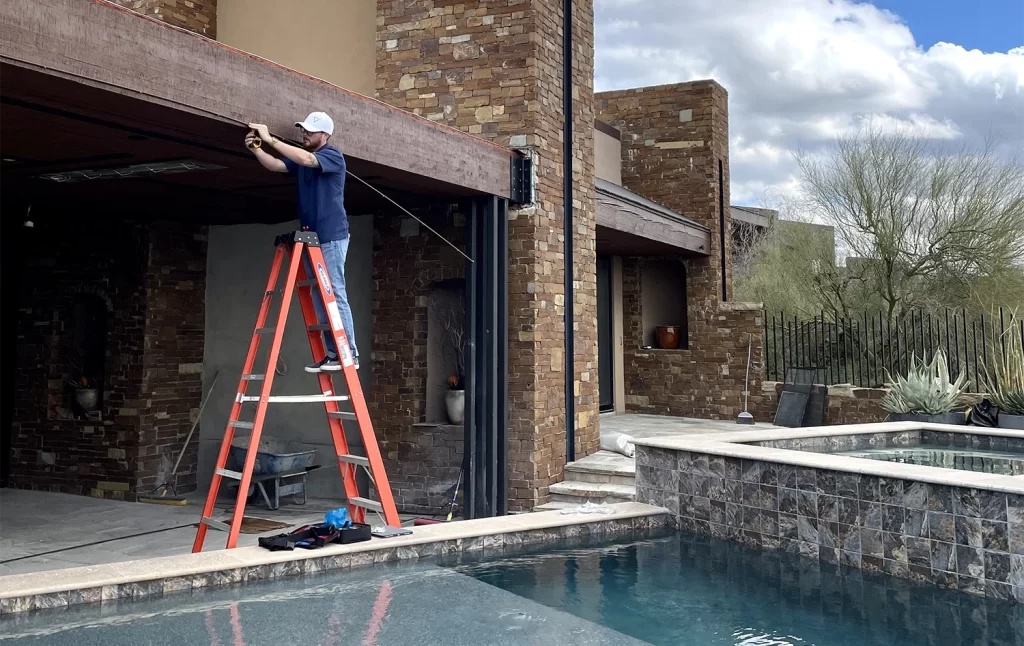 Another element mist team member on a ladder installing a misting system in another arizona backyard