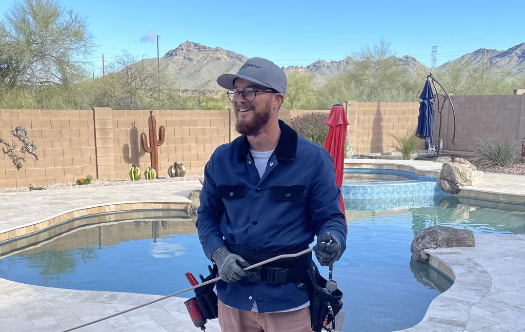 An element mist team member holding parts for a misting system in an arizona backyard